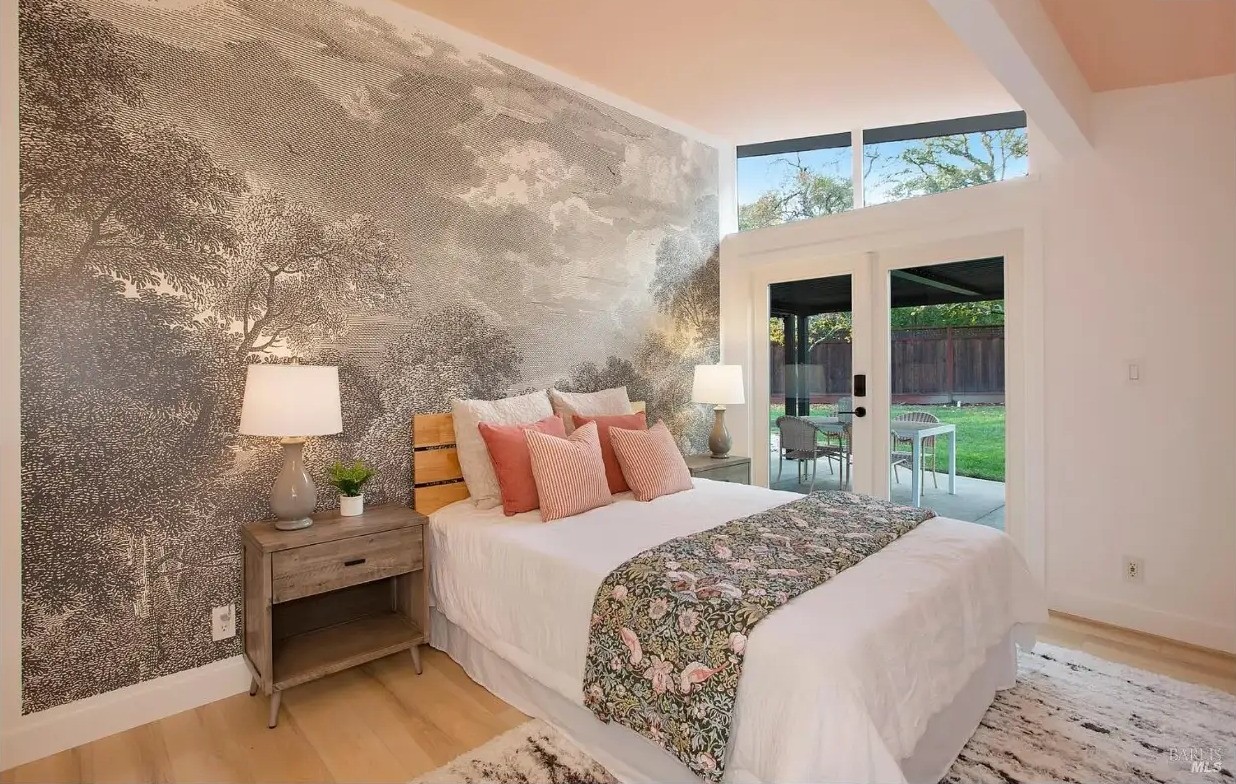 Primary bedroom with mural wall and doors to the patio
