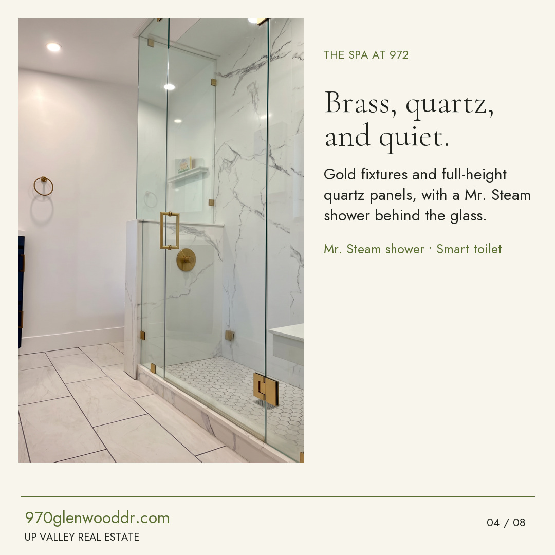 Brass, quartz, and quiet. Clear shower glass shows the gold fixtures and full-height quartz panels; Residence Two includes a Mr. Steam shower and smart toilet.