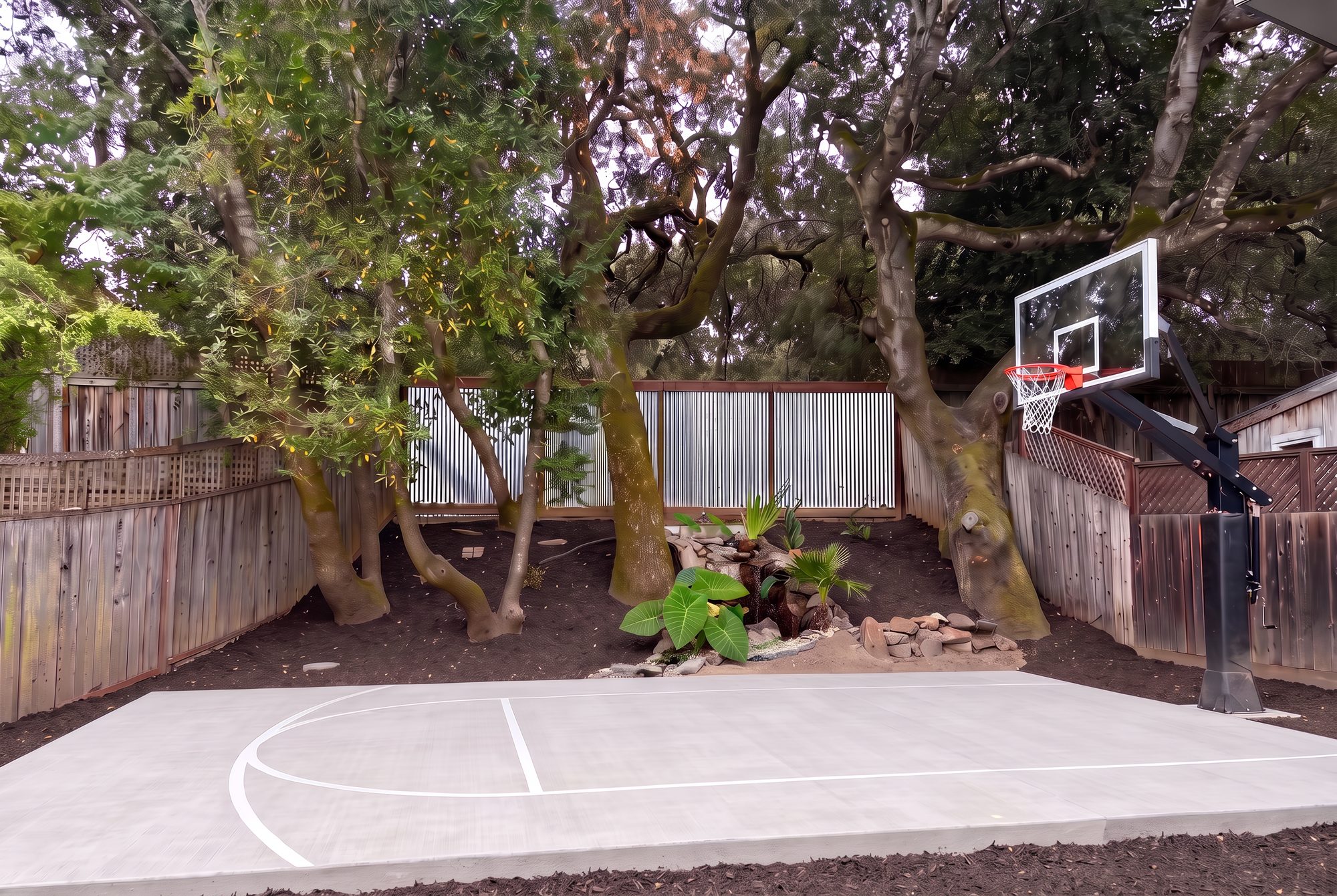 The 19 by 30 foot sport and basketball court with crisp painted free-throw and abbreviated three-point lines, three large oaks and the waterfall behind