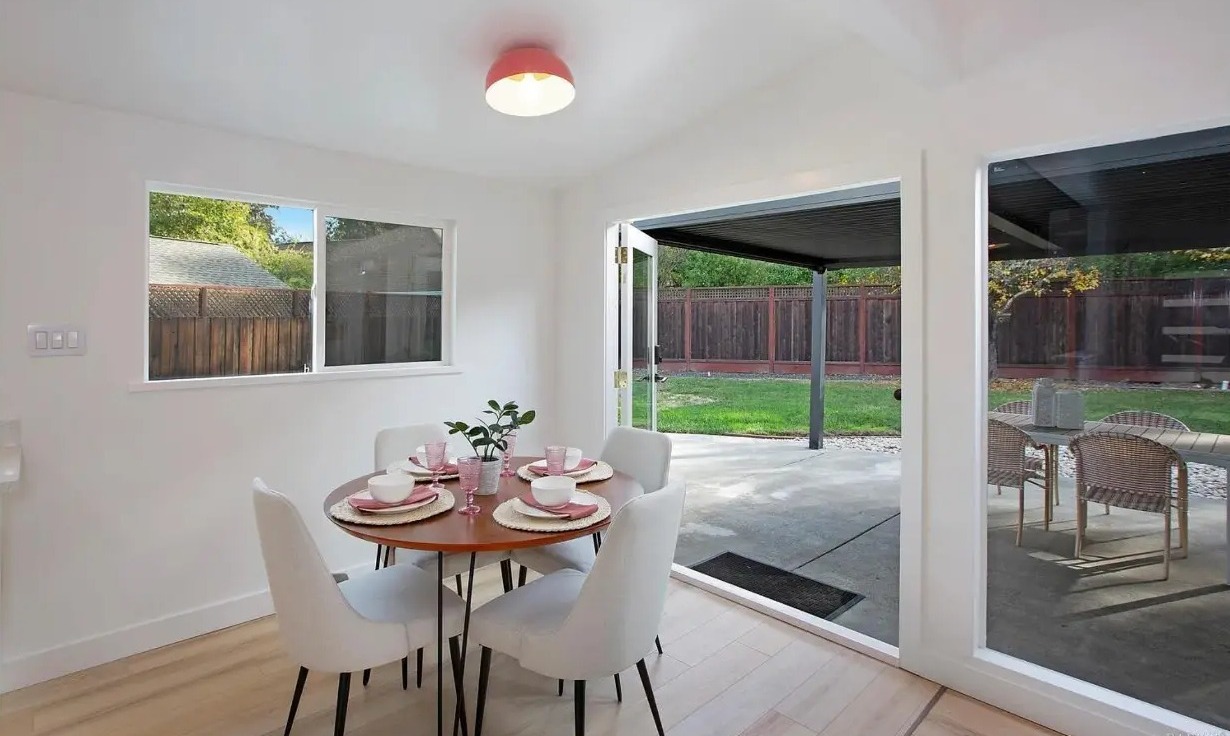 Dining area with the French doors open to the covered patio and lawn