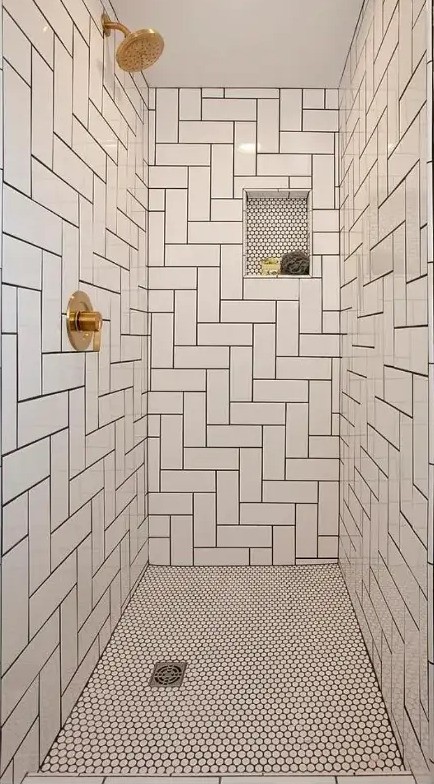 Tiled walk-in shower stall with brass fixtures