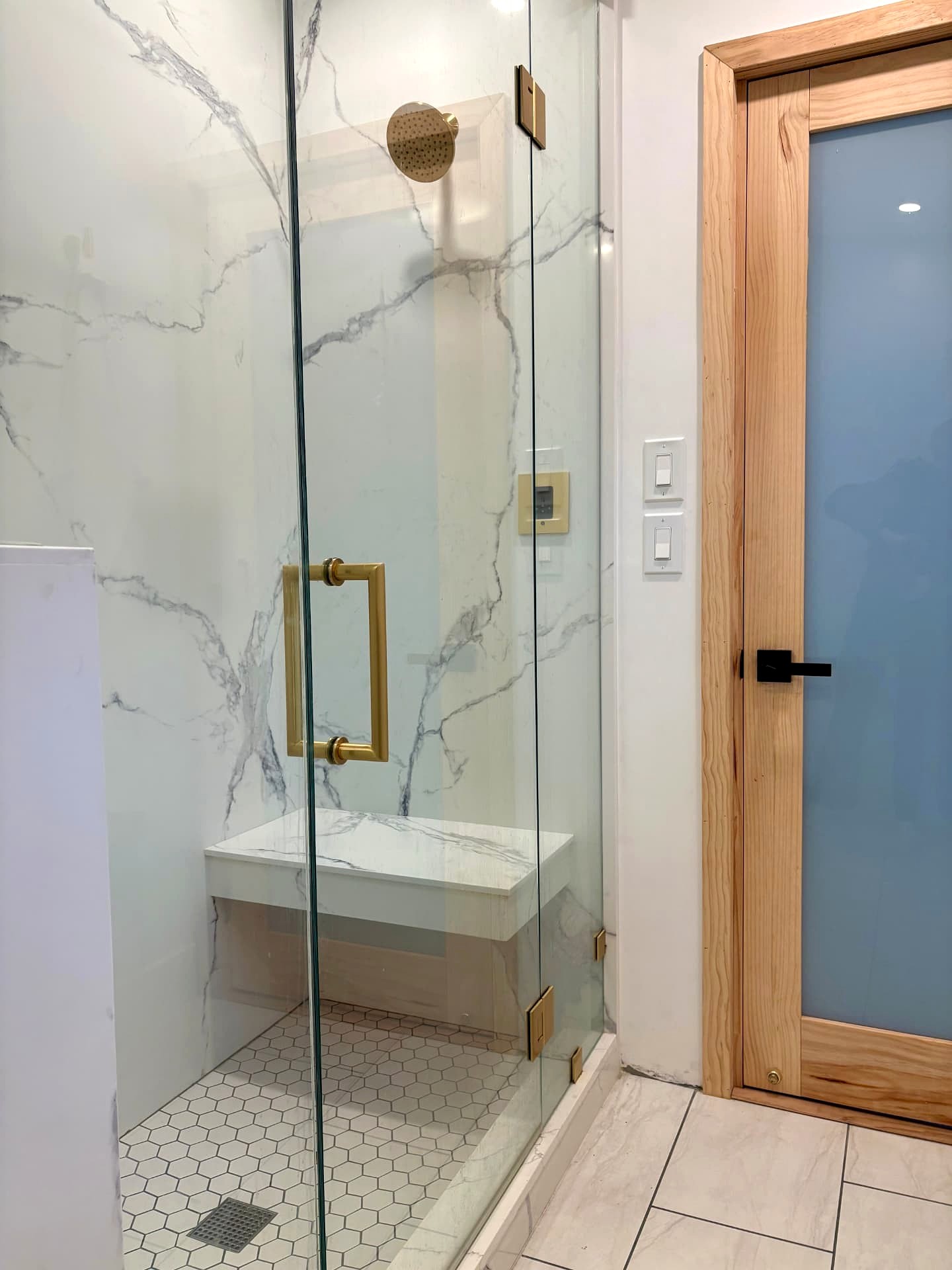Mr. Steam shower in the ADU with built-in bench, brass rain head, and steam control
