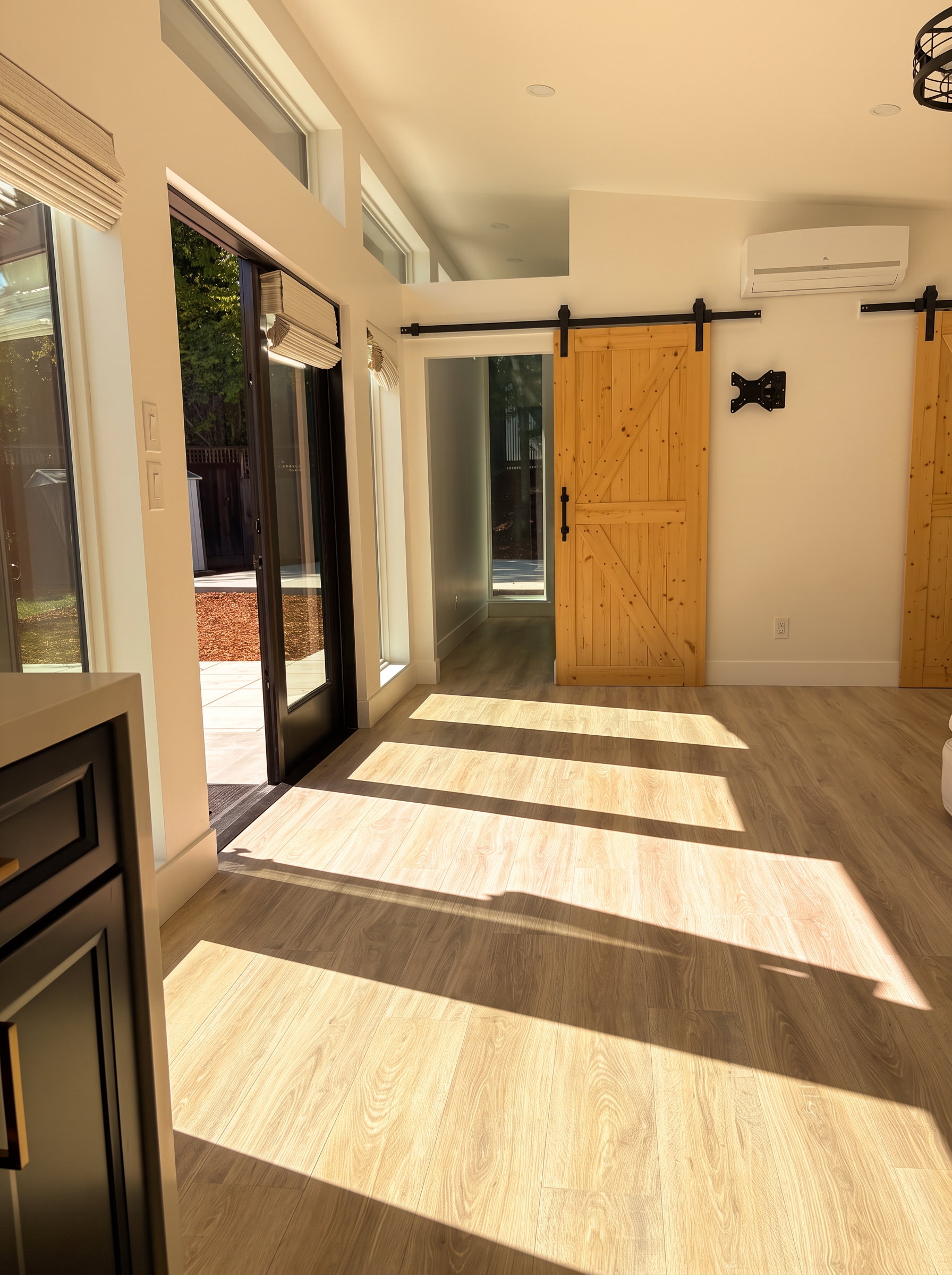 Sunlit ADU living area with clerestory windows and barn door