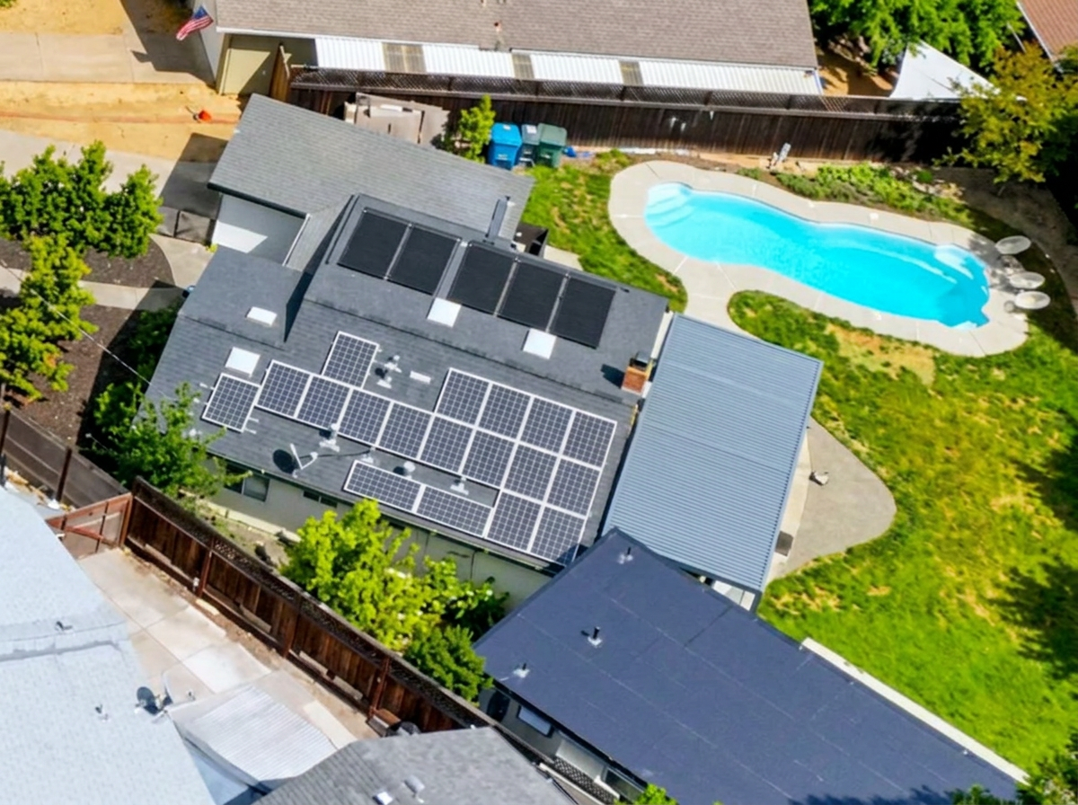 Close-up of the owned rooftop photovoltaic array at 970 Glenwood Drive — framed solar electric modules on the lower roof slope